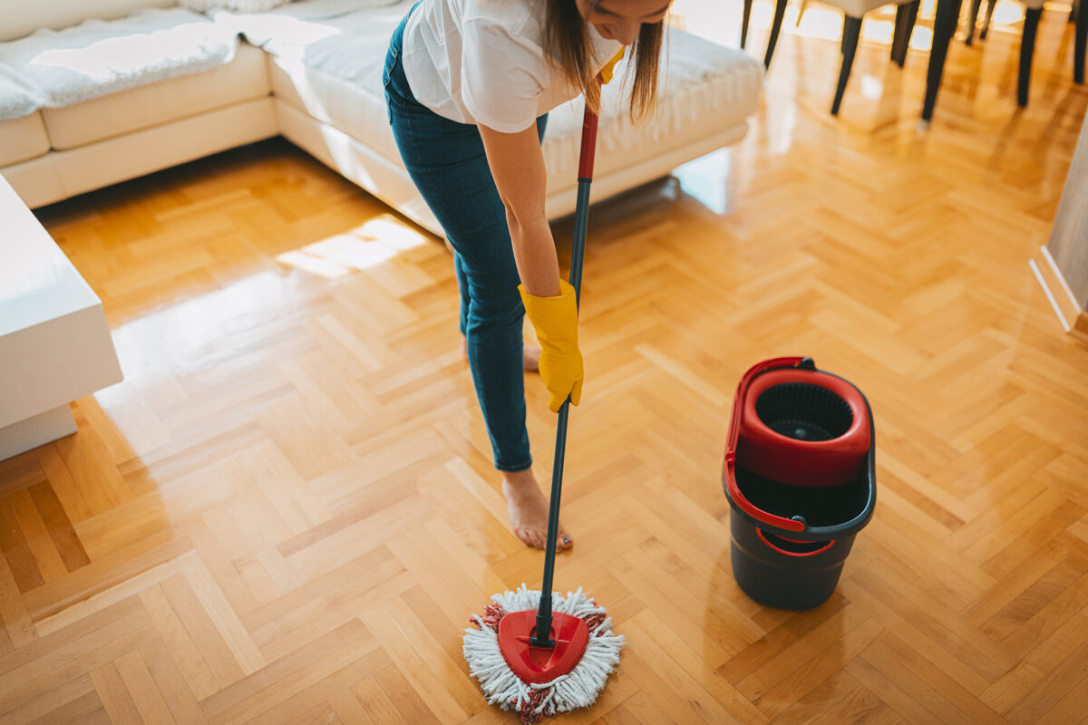 A cleaning woman mopping a parquet floor